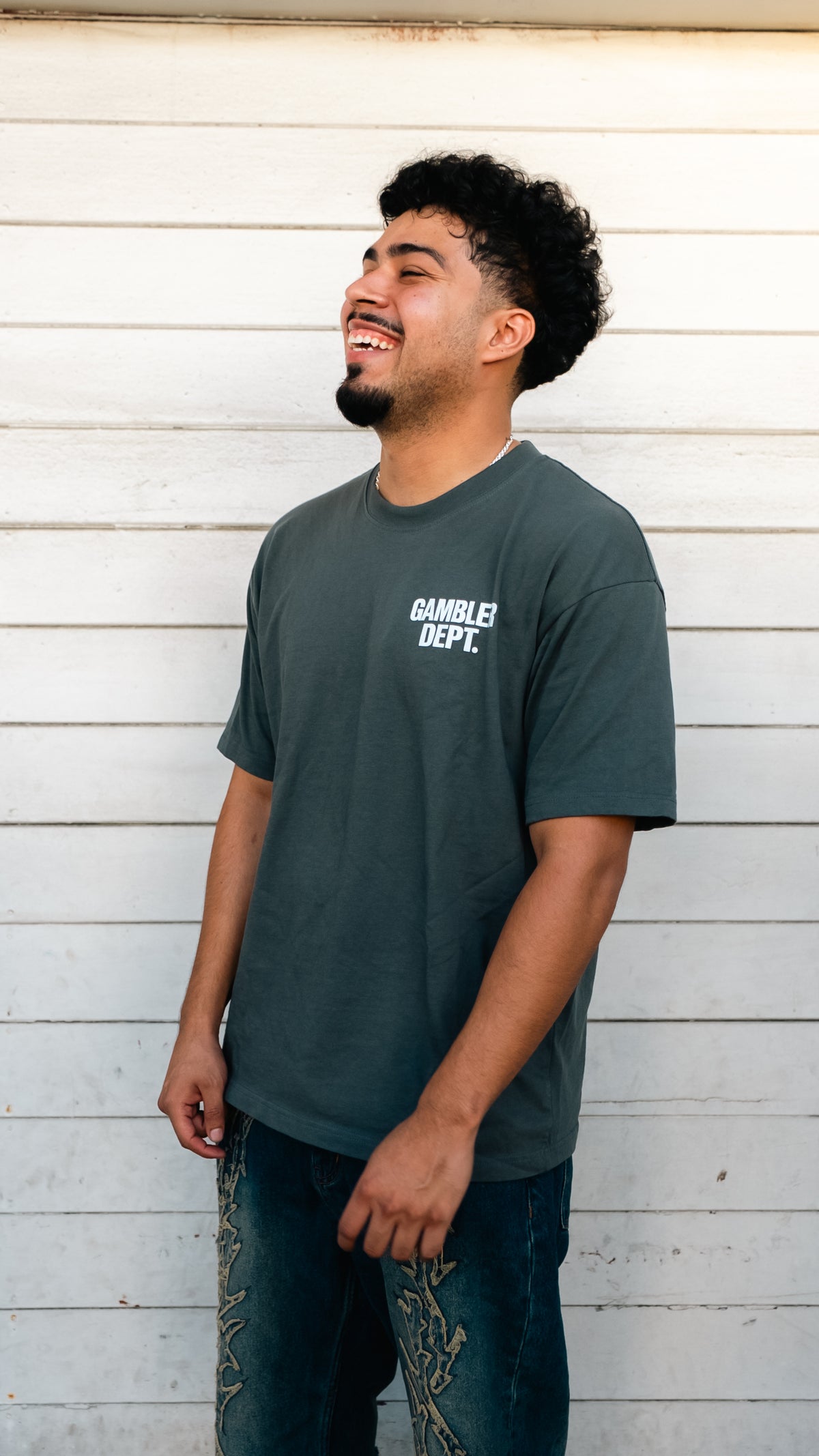 Model smiling in a grey Gambler DPT classic logo tee