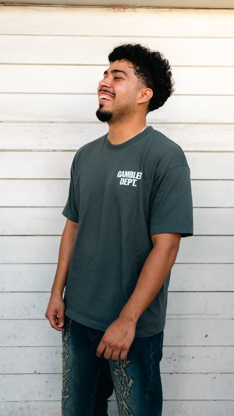 Model smiling in a grey Gambler DPT Classic Logo Tee