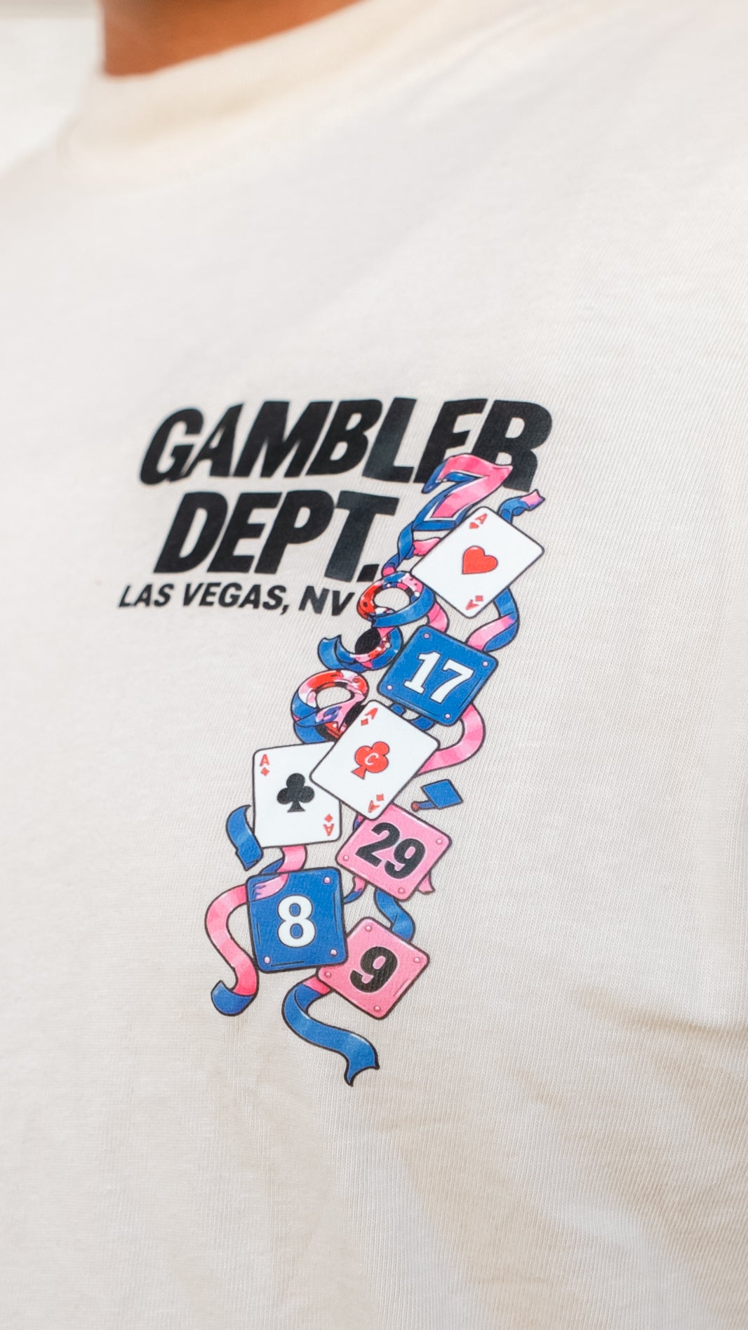 Close-up of cream Gambler DPT playing card shirt graphic